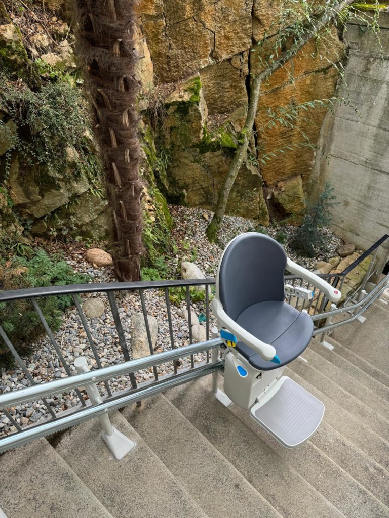 LSM Mobility Siège monte-escaliers installé dans un jardin rocheux à Morges. Solution d'accessibilité élégante et discrète pour les personnes à mobilité réduite.