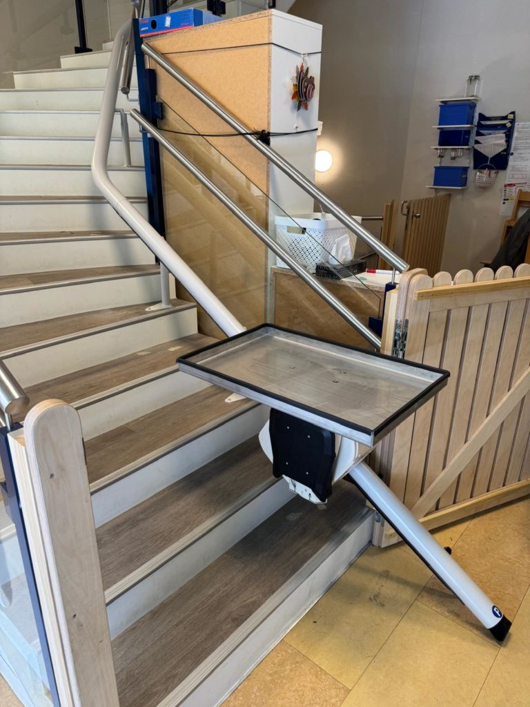 LSM Mobility Monte-escalier de marchandises sur mesure installé dans un escalier intérieur. La plateforme est vide, prête à transporter des objets. Solution idéale pour le transport de marchandises!