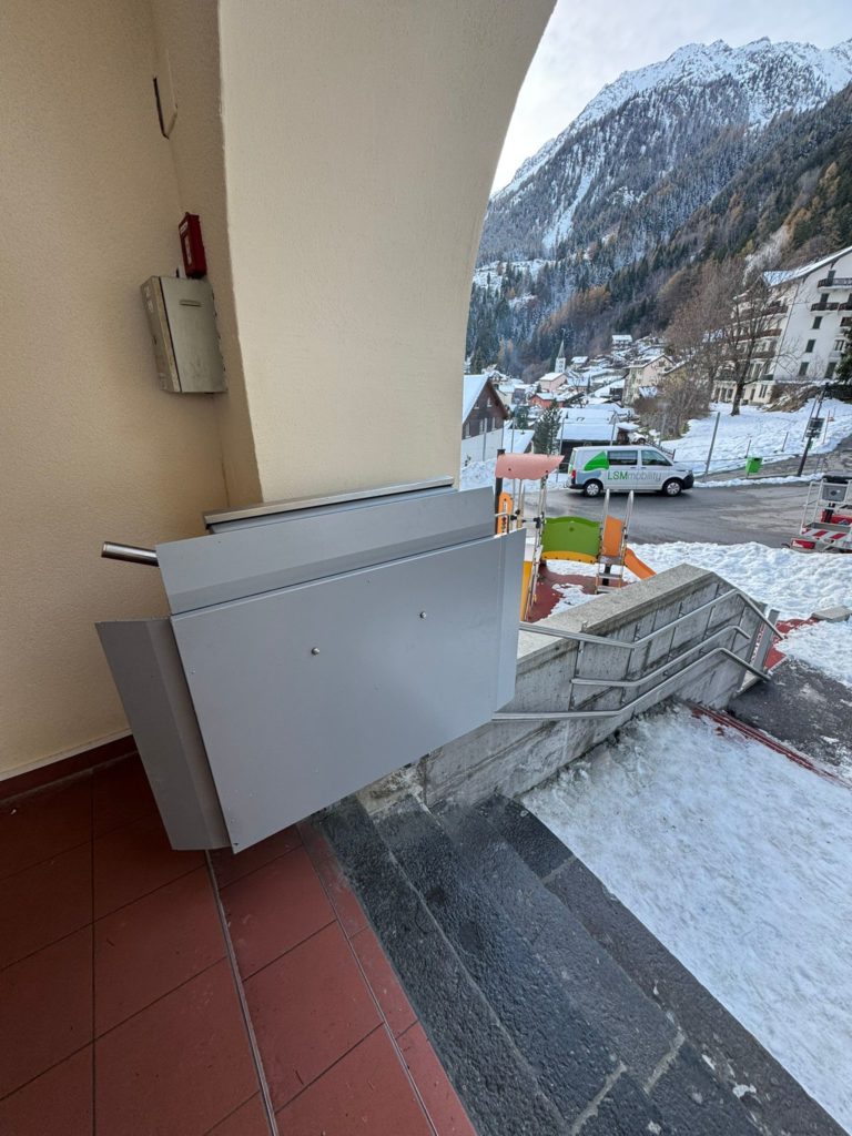 LSM Mobility Plateforme élévatrice installée dans la Vallée du Trient, offrant un accès facilité malgré les escaliers. Vue sur le village enneigé et les montagnes.