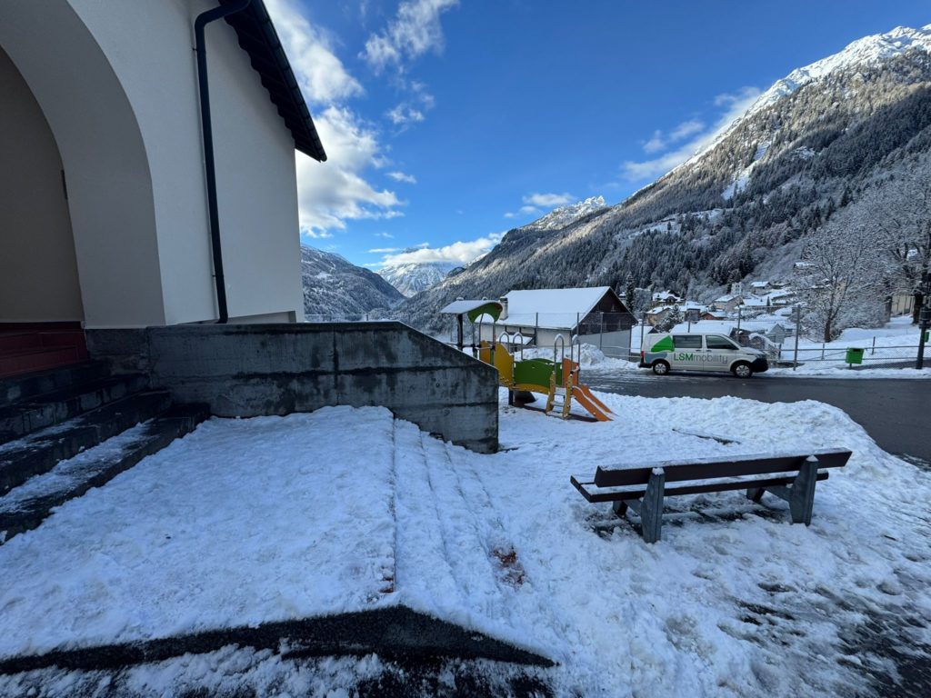 LSM Mobility Paysage enneigé dans la Vallée du Trient, avec une aire de jeux pour enfants, une voiture LSM Mobility et les montagnes en arrière-plan. Installation d'une plateforme en montagne.