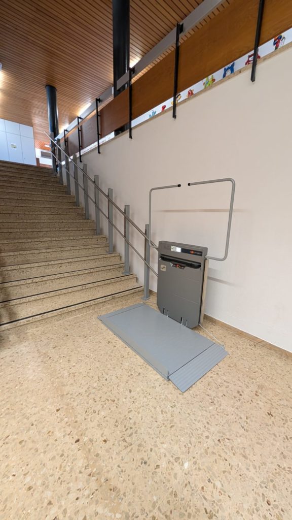 LSM Mobility Plateforme élévatrice pour fauteuil roulant installée à côté d'un escalier dans une école. Solution d'accessibilité pour l'école.