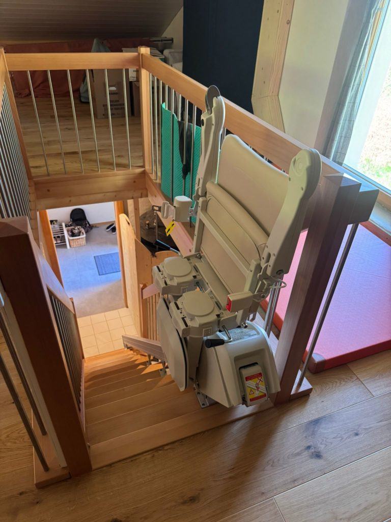LSM Mobility Monte-escalier en bois à côté d'un escalier en bois avec une rampe métallique
