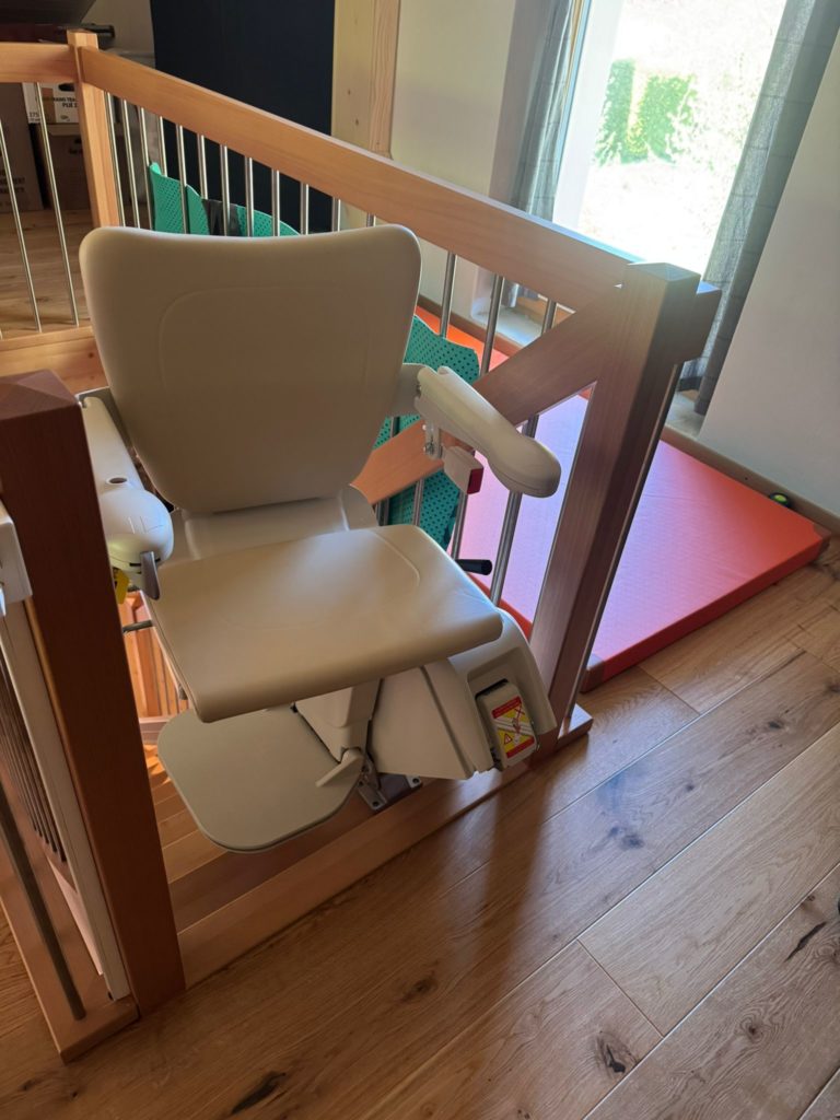 LSM Mobility Siège élévateur beige installé sur un escalier en bois, prêt à l'emploi.