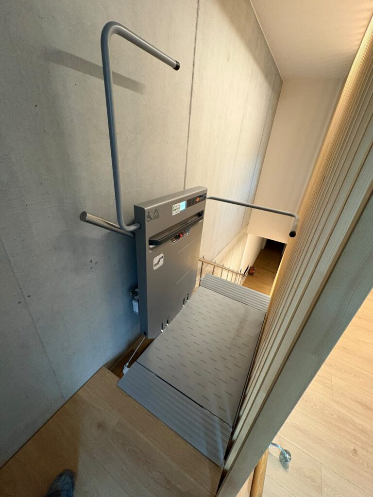 LSM Mobility Plateforme élévatrice pour fauteuil roulant le long d'un escalier en béton et bois.