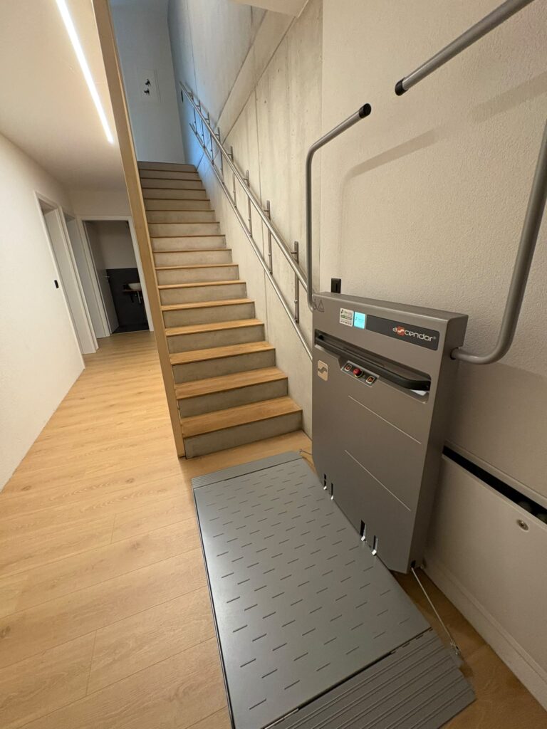 LSM Mobility Plateforme élévatrice Escendor installée près d'un escalier moderne en bois et béton.